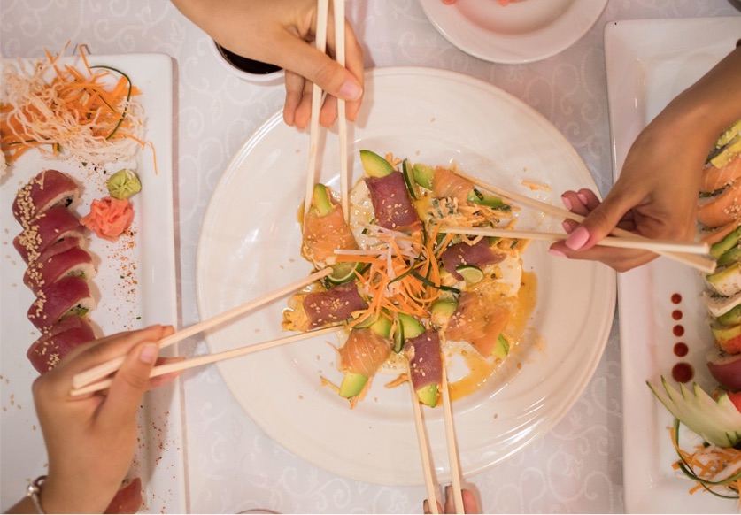 a group of people sharing a tuna sashimi